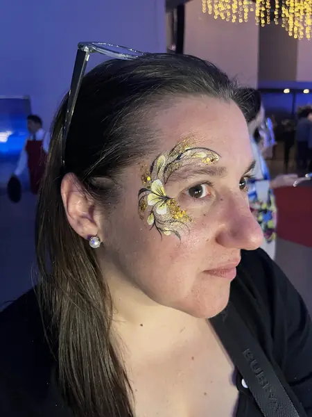 Maquillaje glitter de flor dorada alrededor del ojo