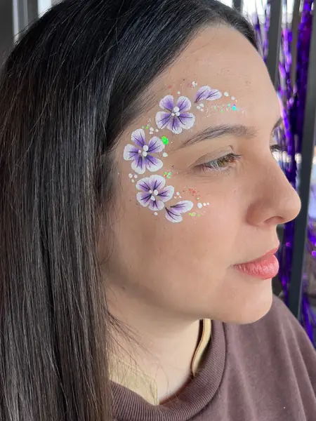 Maquillaje glitter de flores lila alrededor del ojo