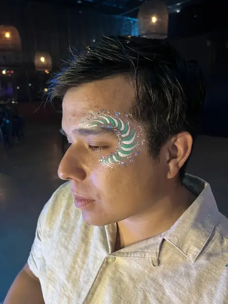 Maquillaje glitter de ondas verdes y blancas en un hombre