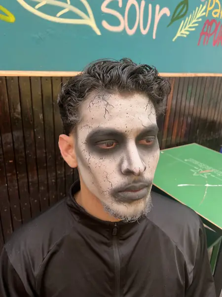 Maquillaje de cadáver con grietas y ojeras oscuras en un hombre