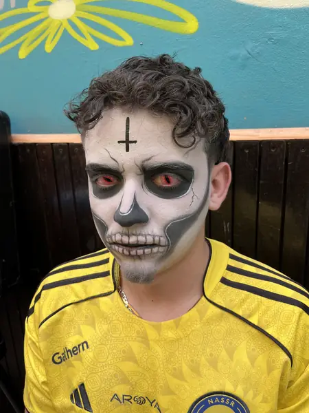 Maquillaje de calavera con ojos rojos y cruz en la frente