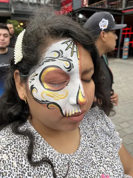 Maquillaje de catrina con detalles dorados en medio rostro