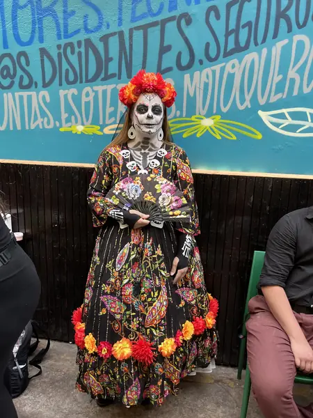 Catrina con maquillaje de rostro y escote y vestido floreado completo