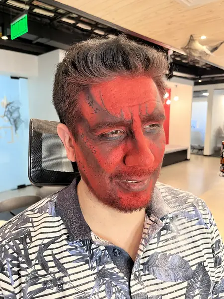 Maquillaje de diablo con rostro y barba rojos en un adulto