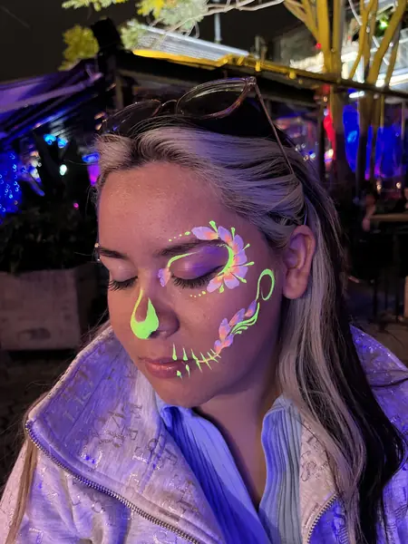 Diseño de Halloween con flores y gota neón en 1/4 de rostro
