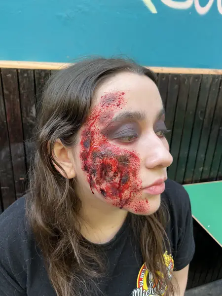 Maquillaje de herida realista en la mejilla de una mujer