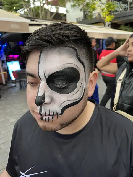 Maquillaje de media calavera en blanco y negro en un hombre, fiesta de Halloween