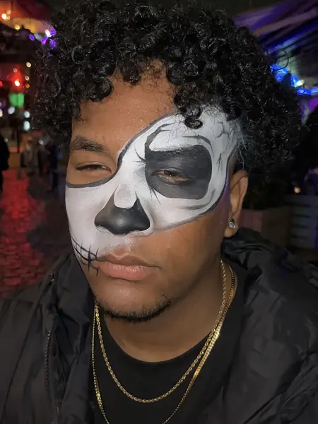 Maquillaje de media calavera blanca y negra en una fiesta de noche