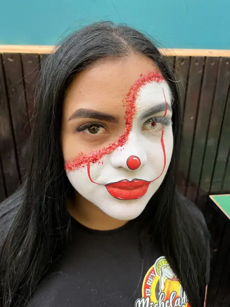 Maquillaje de payasa con glitter rojo en medio rostro