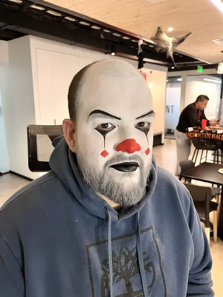 Maquillaje de payaso blanco con nariz roja en un adulto, Halloween en una oficina