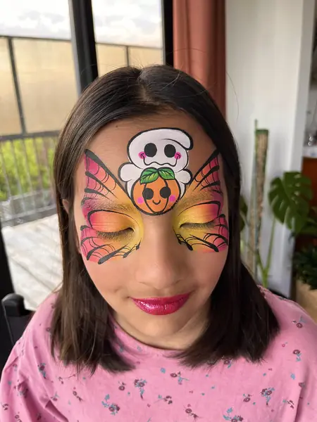 Pinta caritas de Halloween con fantasma, calabaza y alas de mariposa en una niña