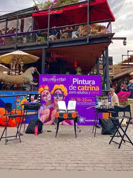 Stand de pintura de catrinas para adultos y niños en Patio Bellavista, con espejos iluminados y sillas de maquillaje