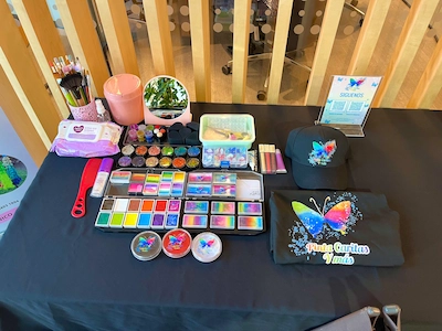 Setup pinta caritas en evento — materiales Aquacolors sobre mesa