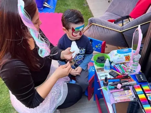 Lorena Sambrano pintando a un niño — pinta caritas profesional Santiago