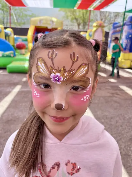 Pinta caritas de reno con astas y nariz en el rostro completo de una niña