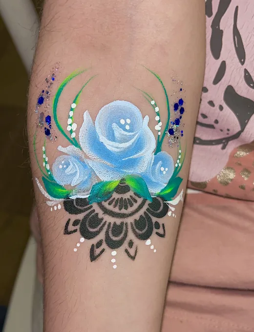 Pinta caritas adulto — rosa azul en brazo con glitter, diseño para matrimonio en Santiago