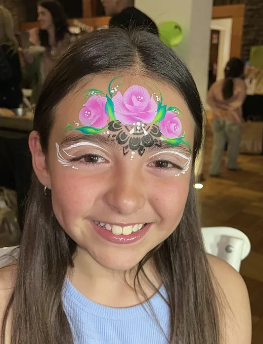 Diseño floral delicado en la frente de una niña — pinta caritas para matrimonio en Santiago